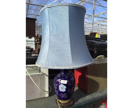 A FLORAL CERAMIC TABLE LAMP WITH BLUE SHADE 