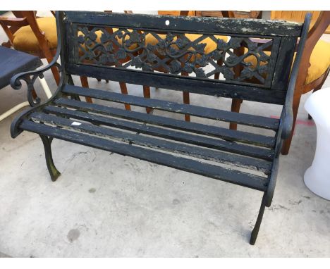 A VINTAGE WOODEN SLATTED GARDEN BENCH WITH CAST ENDS AND BACK PANEL 