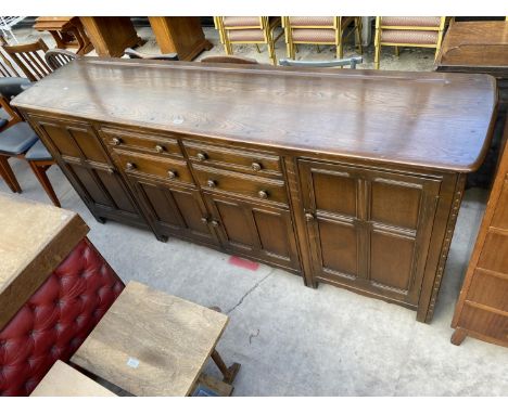 AN ERCOL ELM SIDEBOARD ENCLOSING FOUR DRAWERS AND FOUR CUPBOARDS, 84" WIDE 