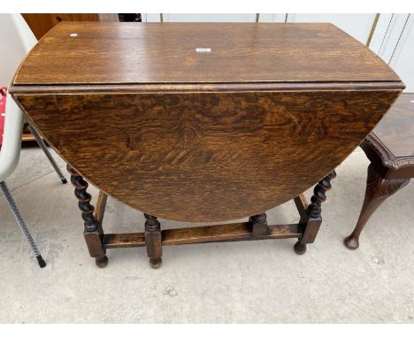 AN EARLY 20TH CENTURY OAK GATE-LEG DINING TABLE ON BARLEY TWIST LEGS 