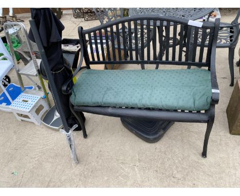 A SLATTED METAL GARDEN BENCH AND A PARASOL 