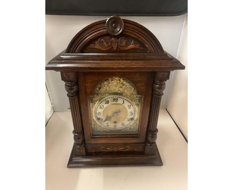 A MAHOGANY WESTMINSTER CHIMING BRACKET CLOCK WITH  A DECORATIVE GILDED FACE AND KEY 