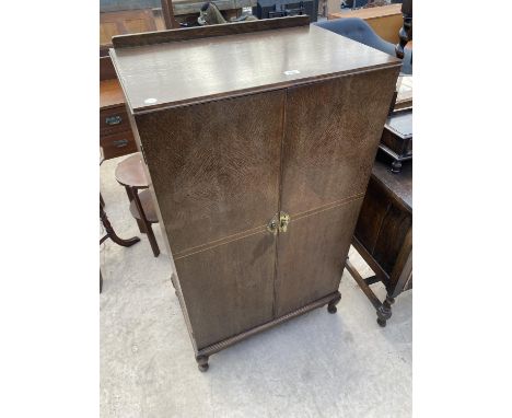 AN EARLY 20TH CENTURY OAK TALLBOY/PRESS ENCLOSING FOUR SLIDES AND SHELF, 28" WIDE 