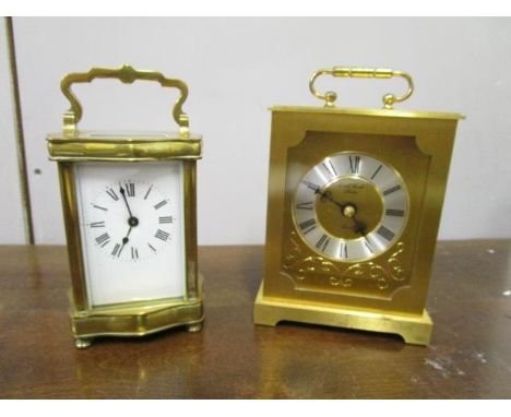 A brass cased five window carriage clock with serpentine facade, white enamel dial, on four turned brass feet, along with a v