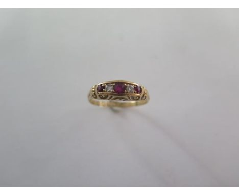 A ruby and diamond half hoop ring - cast scrolled shoulders and bezel set with three mixed cut rubies and two old cut diamond