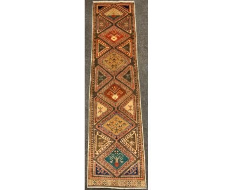 A North west Persian Heriz runner carpet, hand-knotted in earthy tones, with accents of green and blue, 280cm x 70cm. 