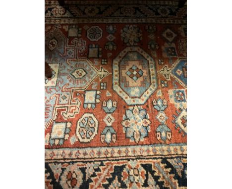 A mid 20th century Middle Eastern woollen runner carpet / rug, hand-knotted in subdued tones of red, blue, cream, and black, 