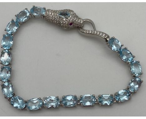 A Silver 925 blue topaz and cz line bracelet with snake head clasp detailed with ruby eyes. 