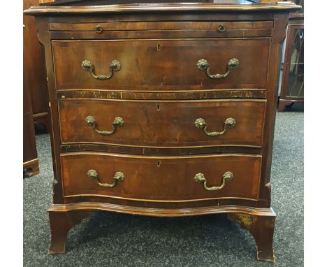 Georgian style serpentine chest, the top with a moulded edge above a pull-out ledge, leading to a bank of three drawers, rais