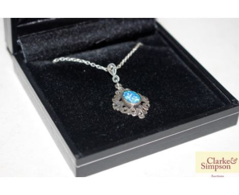 A boxed silver and marcasite and blue opal pendant 