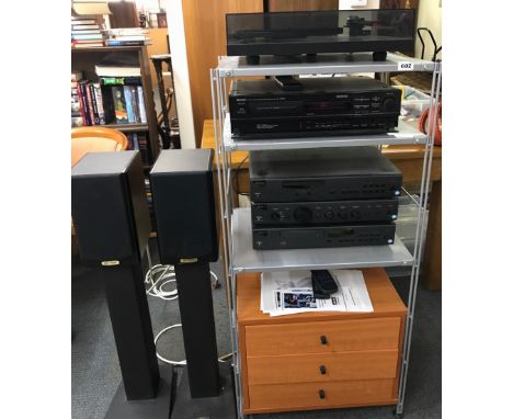 An ARCAM CD player, tuner and amplifier with a pair of RUARK speakers on heavy metal stands accompanied by a Denon VCR and a 