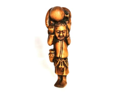 A carved fruitwood netsuke of a man carrying a large octopus on his head, H. 9cm. Condition: good condition.