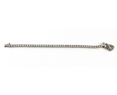 A 925 silver and stone set tennis bracelet with heart charm.