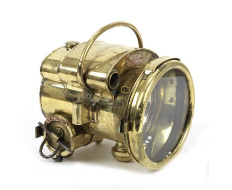 A BRC Alpha self-generating acetylene headlamp, French,model 110, stirrup mounted, brass casing (some wear and denting), 7 in