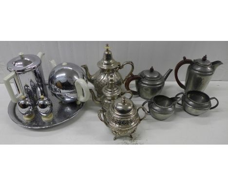 A chrome and ceramic teapot, coffee pot and egg holders with circular tray, a hammered pewter four-piece tea service marked H