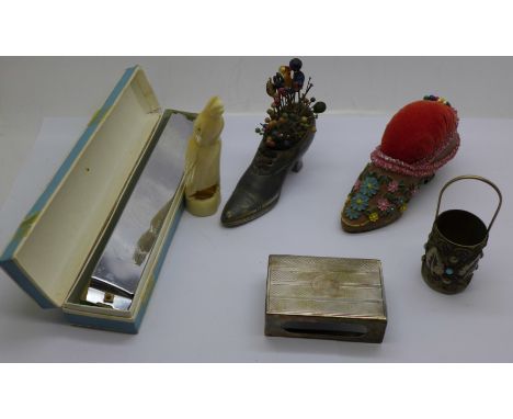 Two pin cushion shoes, a carved ivory penguin, cracked, a Hsinghai harmonica, a silver matchbox holder and a white metal bott