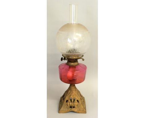 Brass based oil lamp with cranberry glass reservoir
