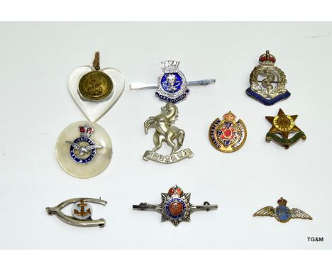 Ten assorted military badges and sweetheart brooches including a WW1 silver and enamel Army Service Corps