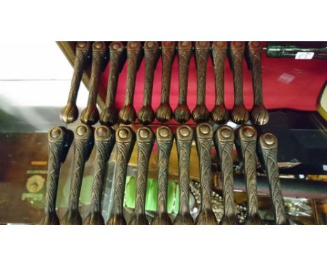 A SET OF TWENTY TWO VICTORIAN CAST METAL STAIR CARPET CLIPS WITH COPPERED FINISH