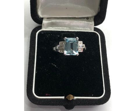 Aquamarine and diamond ring set with large central aquamarine that measures approx 9.5mm by 7.5mm with baguette diamonds eith