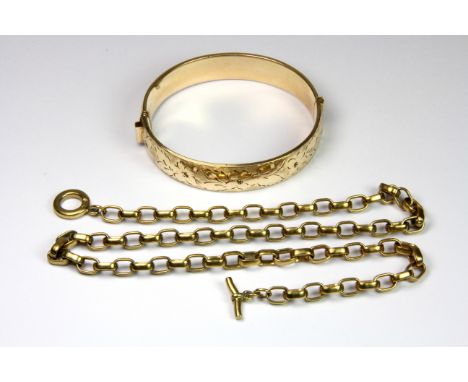 A 9ct metal core bangle together with a T bar yellow metal chain.
