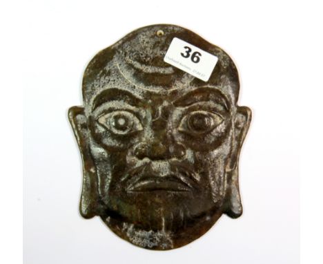 An unusual Chinese carved mixed colour jade panel depicting a man's head, pierced to be mounted on the wall or hang as a tass