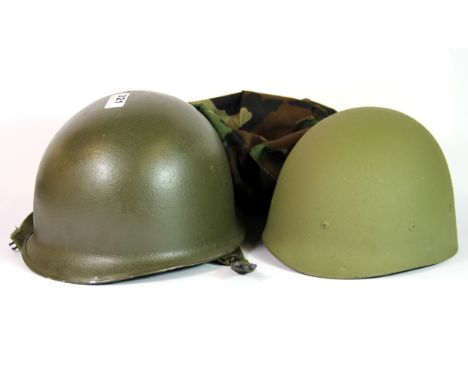 A military helmet, with liner and camouflage cover.