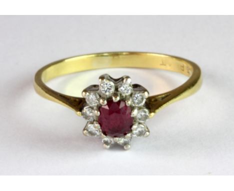 An 18ct yellow gold and platinum (worn stamp 18ct & plat) ruby and diamond cluster ring (Q).