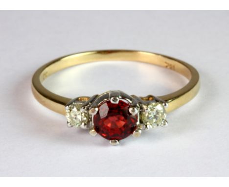 An 18ct yellow and white gold (stamped 18k) ring set with a brilliant cut ruby flanked by diamonds (O).