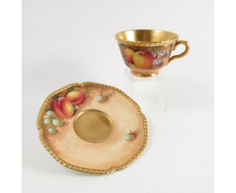 A Royal Worcester cabinet cup and saucer, decorated with fruit to a mossy background by Roberts, with shaped gilt edge to the