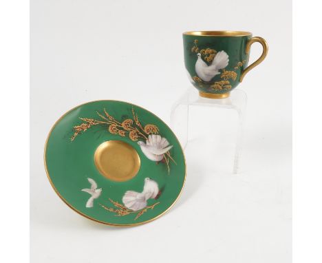 A Royal Worcester cabinet cup and saucer, decorated with white fan tail doves and gilt foliage to a green ground, the cup sig