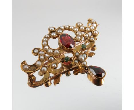 An Edwardian garnet, emerald and seed pearl brooch, stamped 9ct, 3.6cm across, 2.9g gross   Condition report:  One pearl miss