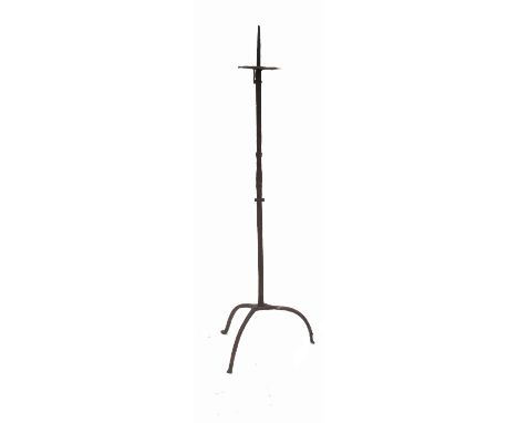 An antique iron pricket candle stand, the octagonal column raised on a tripod base, height 50ins