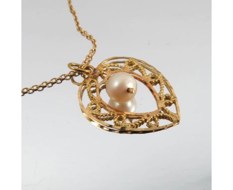 A simulated pearl pendant, within a heart shaped filigree style surround, on a chain, stamped '18k', 4.4g gross