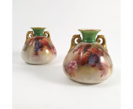 A pair of Royal Worcester Hadley vases, decorated with autumnal fruits and leaves, with a green neck and a pair of gilt handl