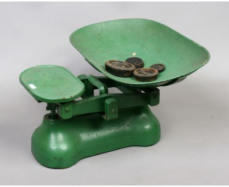 A vintage painted green cast iron set of shop weighing scales, along with a quantity of weights.