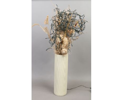 A cream ceramic vase and dried floral display with fairy light decoration.