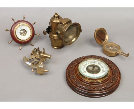 A brass Lucas Ltd Carbide lantern along with a brass sextant and compass and two wall barometers.