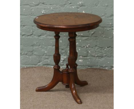 An inlaid mahogany tripod table raised on fluted tapering columns.