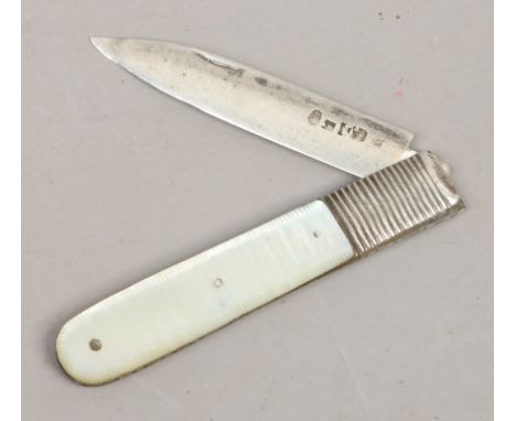 A folding silver fruit knife with mother of pearl scales.