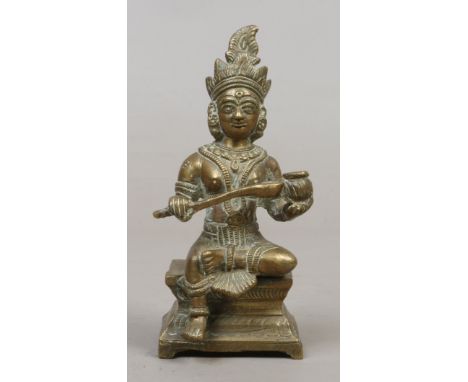An oriental bronze figure of a seated deity raised on a waisted plinth.