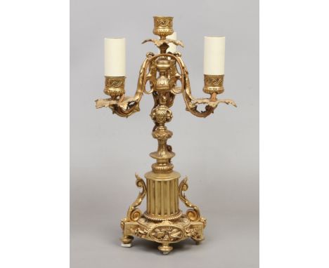 A gilt bronze three branch tablelamp with acanthus formed sconces and raised on a fluted column base.