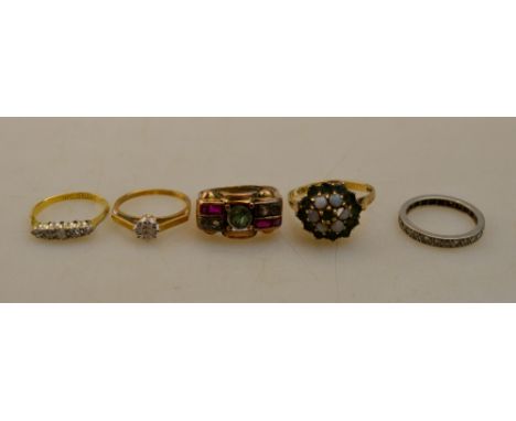 A lot containing five stone set rings including a diamond eternity ring, single stone illusion set diamond ring, five stone d