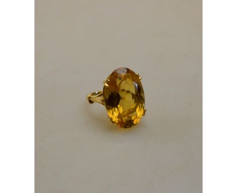 A single stone ring with oval citrine, yellow metal set in four double claw setting, stamped 18ct Condition Report good, unda