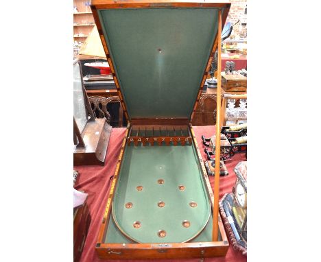An antique mahogany cased folding bagatelle board, the interior baize lined and complete with balls, to one end a score board
