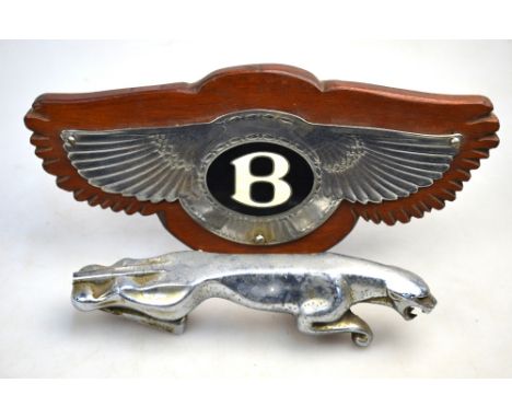 A chromed enamel Bentley badge on wooden plaque, 20 cm to/w a chrome Jaguar car mascot, stamped '7/10091/1 WBB', 18 cm long (