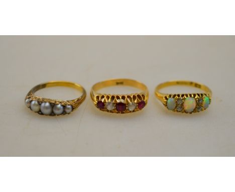 A collection of three rings - all yellow metal set including five pearl, red and white five stone, opal and diamond three sto