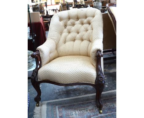 A Victorian dark walnut framed button backed armchairs, raised on floral carved short cabriole front legs to brass castors