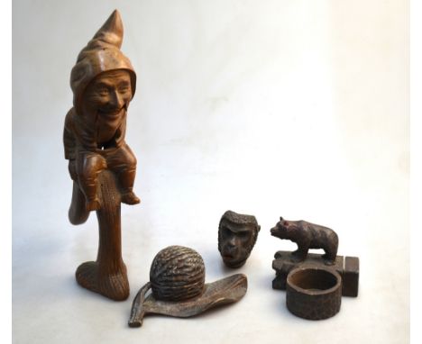 A Black Forest carved wood 'gnome' nut cracker, an inkstand carved as a walnut and leaf, a pin-dish carved with a bear and a 