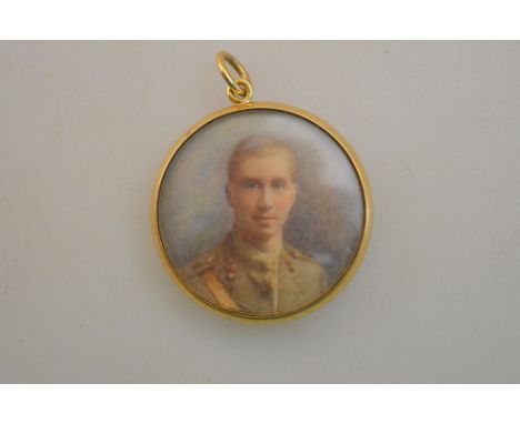 A circular pendant enclosing a watercolour portrait miniature of a young officer, with lock of hair to reverse